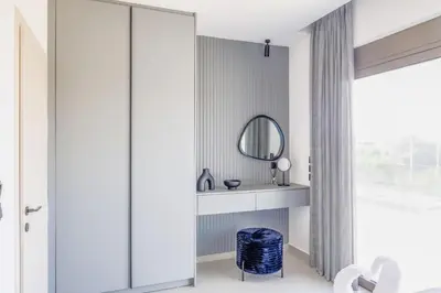 a bathroom with a mirror and a blue stool at Villa Viventia with Heated Pool in Afantou
