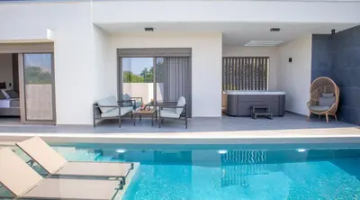 a villa with a swimming pool and a living room at Villa Viventia with Heated Pool in Afantou