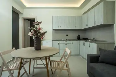 a kitchen with a table and chairs and a vase with flowers at Blue Terra Living in Kremasti