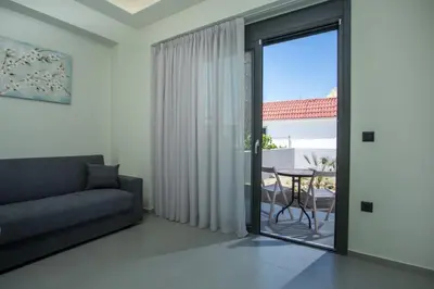 a living room with a couch and a glass door at Blue Terra Living in Kremasti