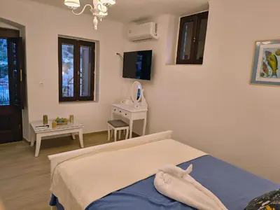 a bedroom with a bed and a table with a mirror at Lirenou Scala Vista in Symi