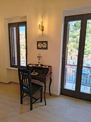a desk with a chair in a room with a window at Lirenou Scala Vista in Symi