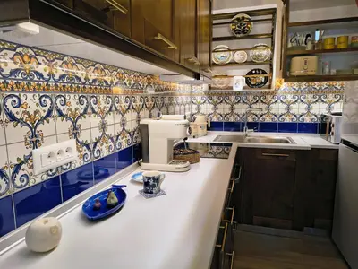 a kitchen with blue and white tiles on the wall at Lirenou Scala Vista in Symi