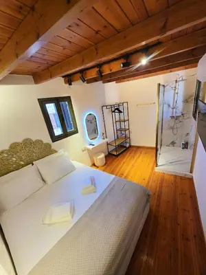 a bedroom with a white bed and a wooden floor at Barbarian in Rhodes Town