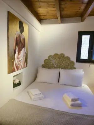 a bedroom with a bed with a painting on the wall at Barbarian in Rhodes Town