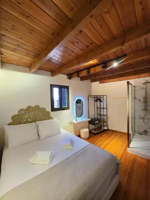 a bedroom with a large white bed with wooden ceilings at Barbarian in Rhodes Town