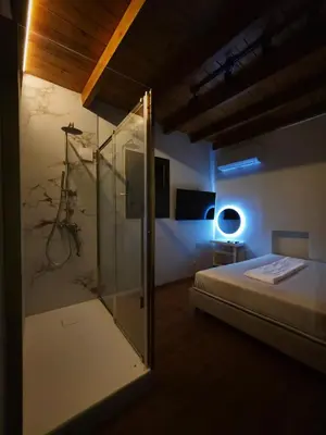 a bedroom with a shower and a bed with a glass door at Barbarian in Rhodes Town