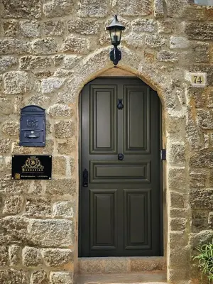 a green door in a stone wall with a street light at Barbarian in Rhodes Town