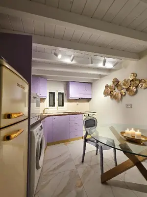 a kitchen with purple cabinets and a glass table at Barbarian in Rhodes Town