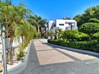 a walkway in front of a white house with palm trees at Casa di Jiovanni Luxury in Asgourou