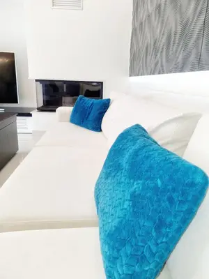 a large white bed with blue pillows on it at Casa di Jiovanni Luxury in Asgourou