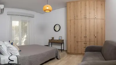 a bedroom with a bed and a cabinet and a couch at Filerimos Nest in Pastida