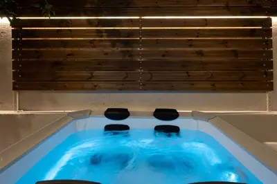 a jacuzzi tub with three chairs in it at Filerimos Nest in Pastida