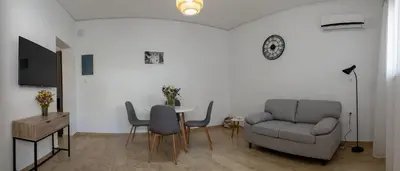 a living room with a table and a couch and a chair at Filerimos Nest in Pastida
