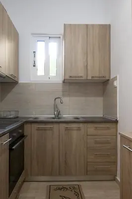 a kitchen with wooden cabinets and a sink at Filerimos Nest in Pastida