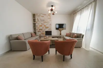 a living room with a couch and a table and chairs at Pura Vida Beach House in Kiotari