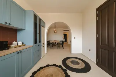 a kitchen with blue cabinets and a dining room at Pura Vida Beach House in Kiotari