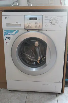a white washing machine sitting in a kitchen at Melpos Room in Kremasti
