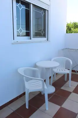 a white table and two chairs and a window at Melpos Room in Kremasti