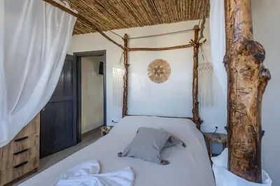 a bedroom with a bed with a wooden canopy at Christos studios and family apartments in Vrachonisída touArchangélou