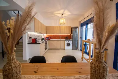 a kitchen with a table with two vases on it at Sia Villa in Lardos