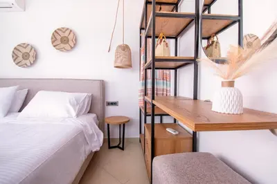 a bedroom with a bed and a wooden desk at Sia Villa in Lardos