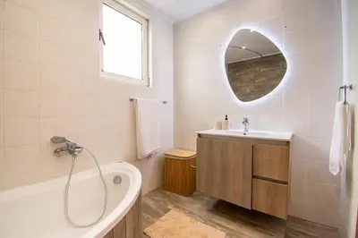 a bathroom with a tub and a sink and a mirror at Sia Villa in Lardos