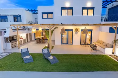 a house with two chairs on a lawn at Sia Villa in Lardos