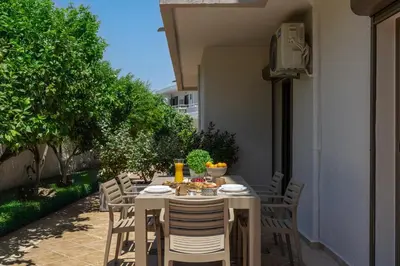 a table with chairs and food on it on a patio at Casa Stefania in Faliraki