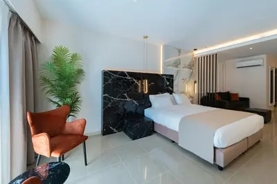 a hotel room with a bed and a chair at Philia Center Suites in Rhodes Town