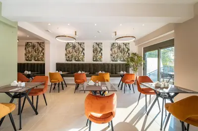 a dining room with tables and chairs and windows at Philia Center Suites in Rhodes Town