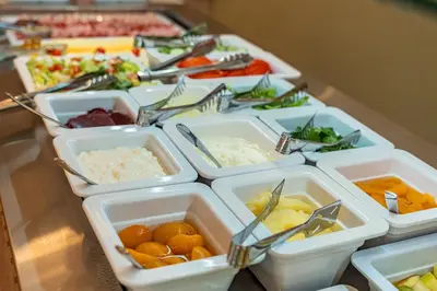 a table with several trays of food on it at Philia Center Suites in Rhodes Town