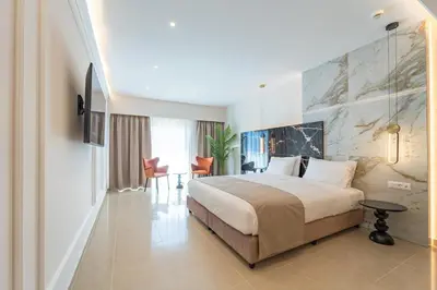 a hotel room with a large bed and a table at Philia Center Suites in Rhodes Town