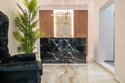 a living room with a fireplace and a chair at Philia Center Suites in Rhodes Town