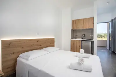 a bedroom with a white bed with two towels on it at GK Home Studios part of GK FITNESS CLUB in Faliraki