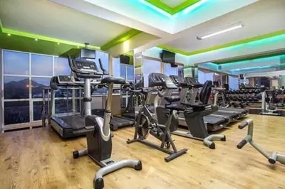 a gym with several treadmills and elliptical machines at GK Home Studios part of GK FITNESS CLUB in Faliraki