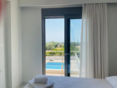 a bedroom with a window with a view of a pool at Anastasia House in Afantou
