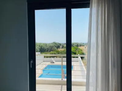 a sliding glass door with a view of a swimming pool at Anastasia House in Afantou