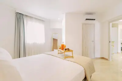 a white bedroom with a large bed and a table at Adama Luxury Villa in Kremasti