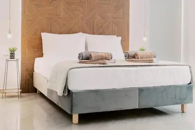 a bedroom with a large bed with a wooden headboard at Adama Luxury Villa in Kremasti