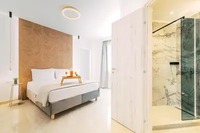 a bedroom with a bed and a glass shower at Adama Luxury Villa in Kremasti