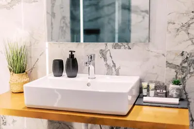 a white bathroom sink with two vases on it at Adama Luxury Villa in Kremasti
