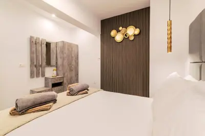 a bedroom with a large white bed and a mirror at Adama Luxury Villa in Kremasti