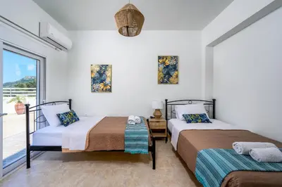 two beds in a room with a window at Mayas Boutique Greece Rhodes Kremasti in Kremasti
