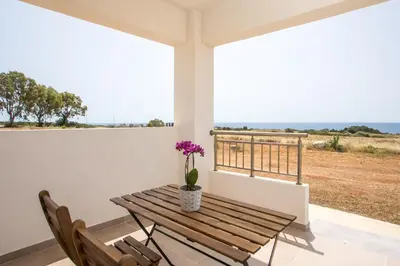 a wooden table with a vase of flowers on a balcony at Bless View Studios in Lachania