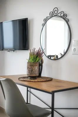 a table with a chair and a mirror at Bless View Studios in Lachania