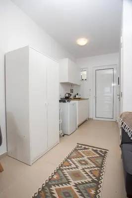 a living room with white cabinets and a kitchen at Bless View Studios in Lachania