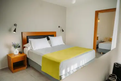 a bedroom with a large bed with a yellow blanket at Amphitryon City Hotel in Rhodes Town