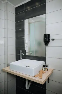 a bathroom with a white sink and a mirror at Amphitryon City Hotel in Rhodes Town