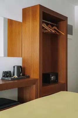 a room with a cupboard with a microwave and a bed at Amphitryon City Hotel in Rhodes Town